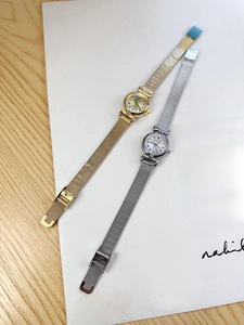 Detail of vintage mesh strap quartz watches with Roman numeral dials in gold and silver