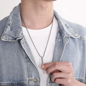 Ciondolo a proiettile argento su modello con catena a sfere in stile minimalista