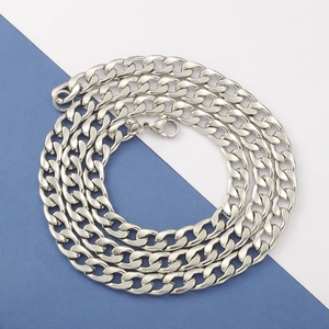 Close-up of a silver Cuban link chain necklace with lobster clasp on blue and white background