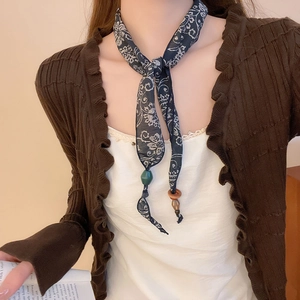Close-up of vintage paisley silk scarf necklace with wooden rings and green beads