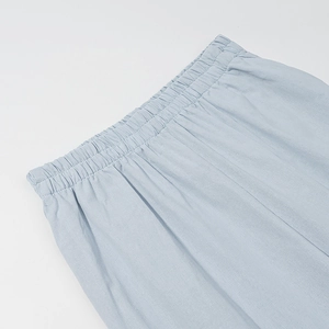 Close-up of light blue elastic waistband with reinforced stitching on cotton pants