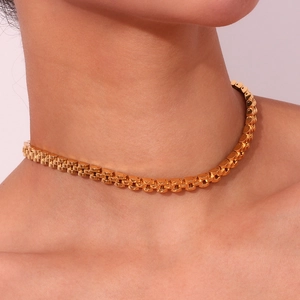 Detail of 18K gold-plated 6mm watch band style stainless steel choker on a female model