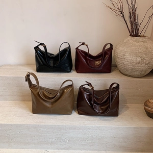 Large vintage leather tote bags in four classic colors on minimalist stone steps