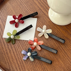 Five colorful acetic acid flower hair clips with pearl centers on black duckbill clips