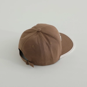 Détail de la casquette en coton marron avec liseré contrasté et boucle en métal réglable