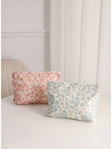 Floral print makeup bag set in pink and blue fabric with minimalist design on table