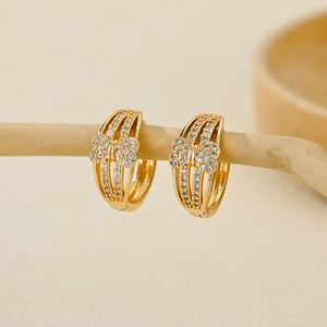 Detail of gold-plated hoop earrings featuring hollow lines and zircon butterfly design