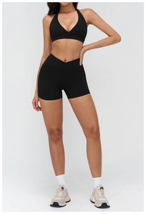 Detail of black cross-waist gym shorts and matching cross-neck sports bra set