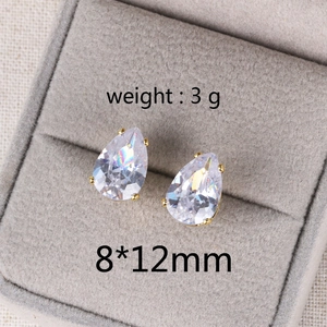 Macro shot of 8x12mm teardrop zircon earrings in gold bezel set on velvet