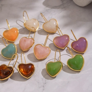 Boucles d'oreilles cœur en résine colorée avec cadre doré sur fond de marbre pour femmes