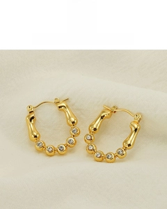 Détail des boucles d'oreilles créoles plaquées or 18 carats avec zircons brillants