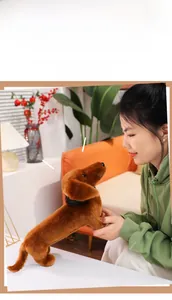 Brown plush dachshund doll held by a model in a warm, cozy living room setting