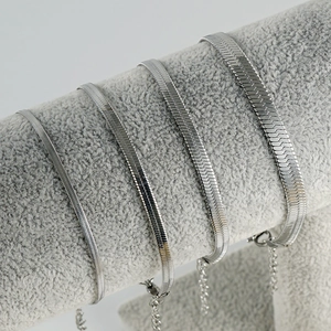 Set of four silver snake chains in varying widths with adjustable length on a grey display