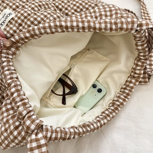 Close-up of quilted plaid backpack interior with spacious pocket and smooth lining