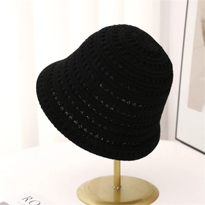 Dettaglio cappello da sole nero all'uncinetto con motivo traforato su supporto metallico