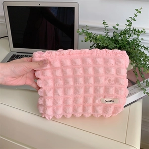 Detail of pink bubble textured makeup bag with soft 3D knitted fabric and metal zipper