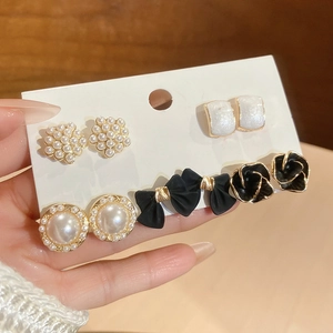 Détail d'un ensemble de boucles d'oreilles vintage avec perles et nœuds noirs sur carte