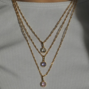 Three-layer gold stainless steel necklace with round birthstones in pink and purple colors