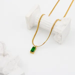 Detail of emerald green rectangular stone set on a golden snake chain necklace