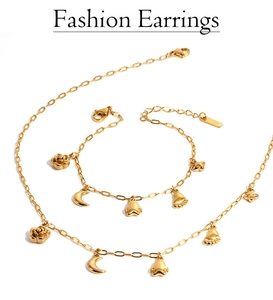 Detailed shot of golden necklace and bracelet set featuring rose and moon charms