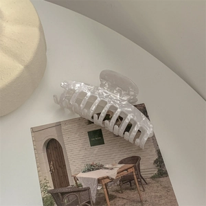 Detailed view of the marble texture on a large pearl white acetic acid hair claw clip