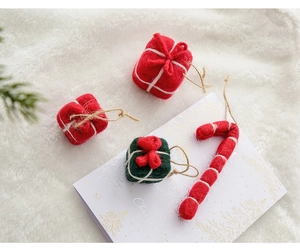 Detailed view of wool felt candy cane and gift box ornaments for Christmas decor