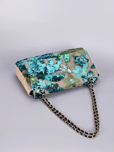 Macro shot of blue and green sequin floral embroidery and gold chain strap detail