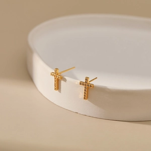 Macro shot of 18K gold plated cross stud earrings with sparkling cubic zirconia inlay