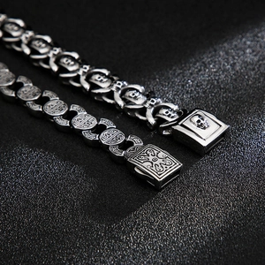 Dettaglio macro di bracciali da uomo in acciaio con teschio e incisioni gotiche