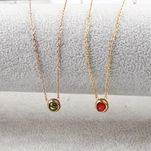 Makroaufnahme von Halsketten aus Roségold und Gold mit grünen und roten Zirkonia-Anhängern