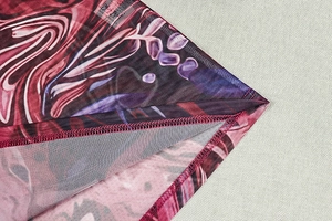 Detailed close-up of retro abstract print mesh fabric with neat overlock hem stitching