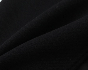 Macro shot of high-quality black wool fabric texture and soft folded textile material