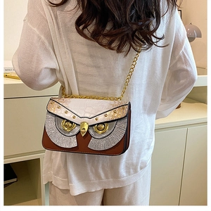 Détail du sac bandoulière hibou avec yeux dorés et bandoulière chaîne sur modèle