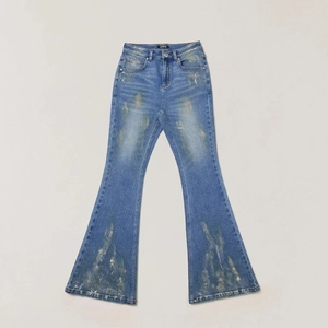 Detail of flared blue denim jeans with hand-painted gold distressed texture and fading
