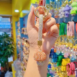 Dettaglio di un portachiavi a fungo con strass arancioni e chiusura in metallo dorato