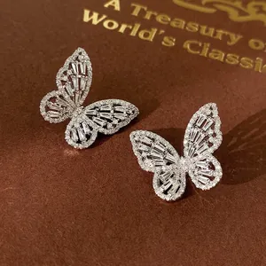 Sparkling silver butterfly stud earrings with marquise cubic zirconia on leather background