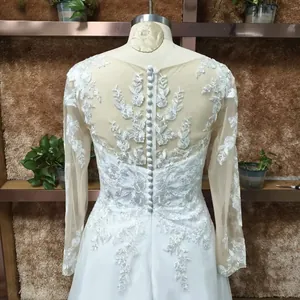 Detail of elegant lace embroidery on sheer mesh back with buttons of a white wedding gown
