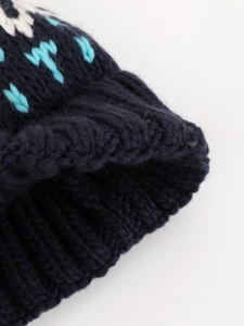Detailed view of the navy blue knit beanie showing arrow patterns and thick textures