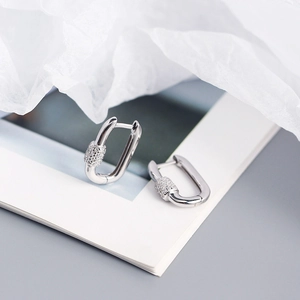 Macro shot of silver buckle hoop earrings with sparkling pavé cubic zirconia details