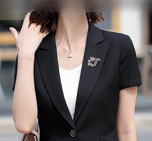 Détail d'une broche renard en strass épinglée sur le revers d'un blazer noir