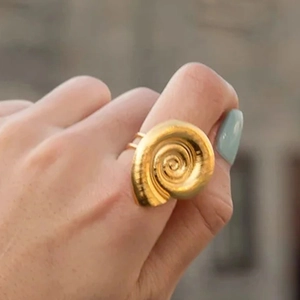 Close-up of golden irregular spiral shell design ring in 18k gold plated titanium steel