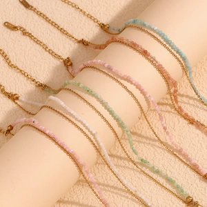 Detail of 18K gold-plated O-chains with colorful amazonite beads on a display stand