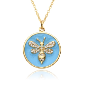 Detail of gold bee pendant on blue enamel with crystals and fine O-chain necklace