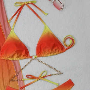 Detail of gradient bikini top featuring golden metal chain connectors and halter ties