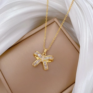 Macro view of a gold-plated butterfly necklace with sparkling zircon stones on silk