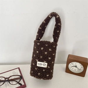 Detail of plush brown fleece cup holder bag with cream polka dots and soft texture