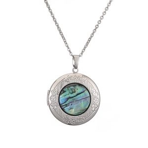 Close-up of silver vintage locket necklace featuring iridescent natural abalone shell inlay