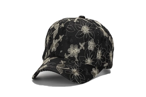 Close-up of intricate cream flower embroidery on a black cotton baseball cap fabric