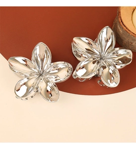 Close-up of polished silver flower hair claws with a glossy metallic finish and petals