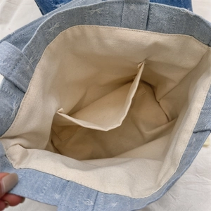 Détail du sac en jean montrant la doublure en toile beige et la poche interne